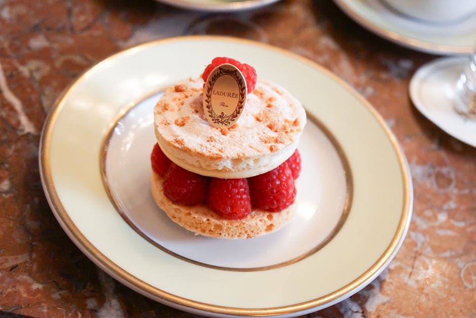 Mouthwatering raspberry macaron dessert elegantly presented on a plate at Ladurée, Paris.